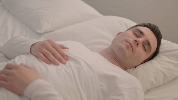 Unavený mladý muž spí v posteli doma - Fotografie, Obrázek