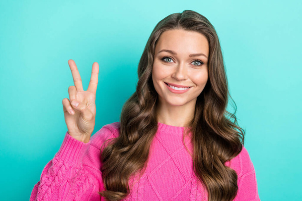 Portrait of adorable good mood girl curly hairstyle wear purple pullover toothy smiling show v-sign isolated on teal color background. - Photo, Image