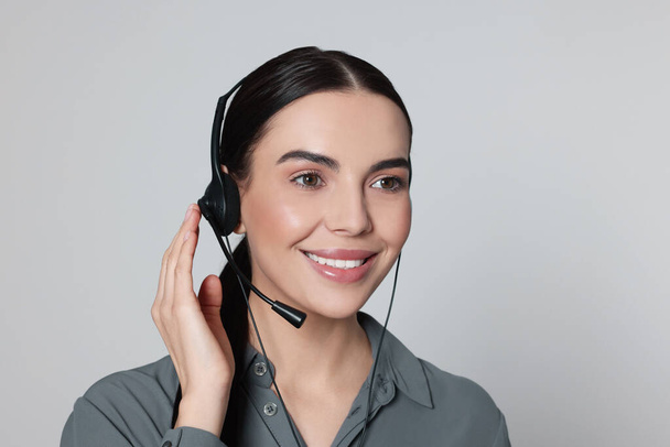 Hotline operator with modern headset on light grey background. Customer support - Foto, Imagem