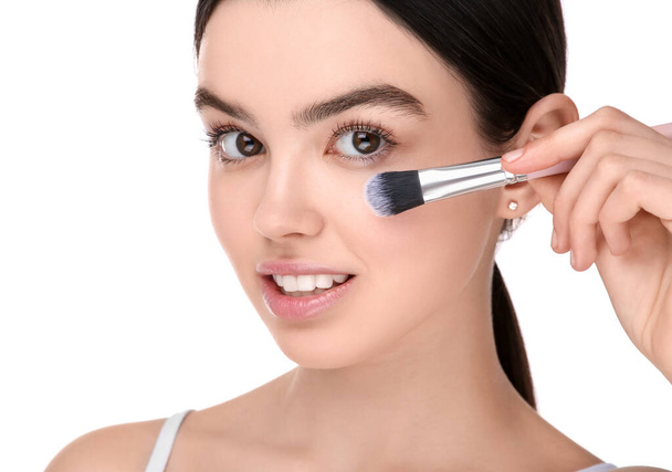 Teenage girl with makeup brush on white background - Φωτογραφία, εικόνα