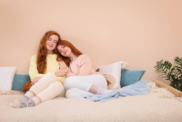 Portrait of beautiful young redhead sisters in bedroom. Space for text - Foto, Imagen