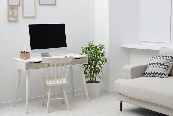 Espaçoso espaço de trabalho com mesa, cadeira, computador e vasos de plantas em casa - Foto, Imagem