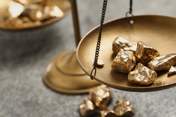 Vintage scales with gold nuggets on grey table, closeup. Space for text - Fotografie, Obrázek