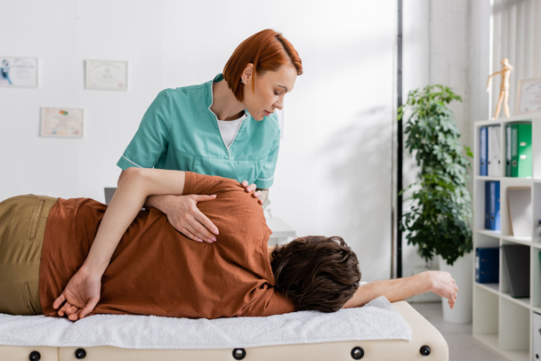 osteopath making shoulder massage to injured man during rehabilitation treatment - Photo, Image