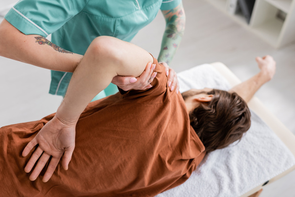 osteopath doing rehabilitation massage on injured arm of man in rehab center - Fotoğraf, Görsel