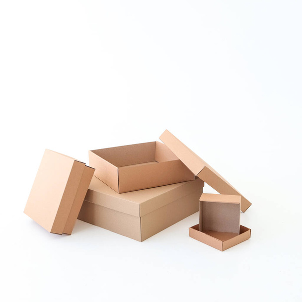 Many craft boxes of different sizes on a white background. Place for text and logo. The concept of packaging, moving, gifts. High quality photo - Foto, Imagem