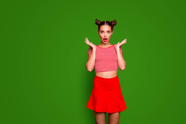 Sporty girl isolated on red background with copy space for text in red skirt and striped shirt impressed by good unexpected news Concept of human feelings. - Photo, image