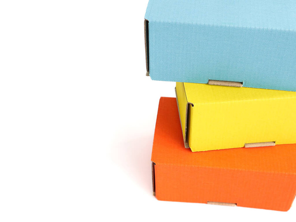 Colored craft boxes on a white background. Orange, blue, yellow. Place for text and logo. The concept of packaging, holiday, gifts. High quality photo - Foto, Imagem