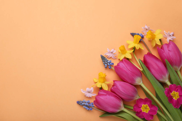 Beautiful bouquet with different flowers on orange background, flat lay. Space for text - Foto, Imagen