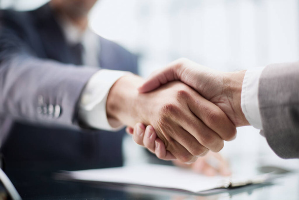 Photo of business handshake over workplace in office - Valokuva, kuva