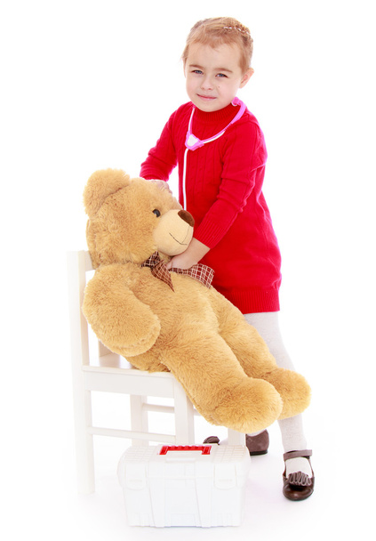 vicces kis lány játszik a kórházban hallgatja teddy bea - Fotó, kép