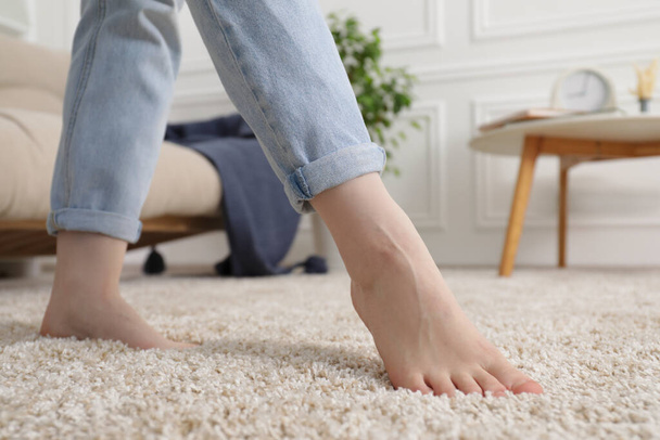 Woman standing on soft brown carpet at home, closeup - Foto, Imagen