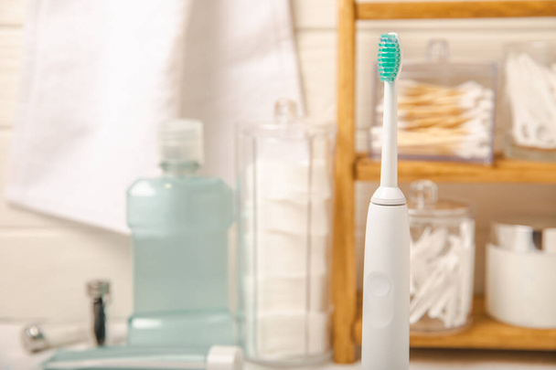 Modern sonic or electric toothbrush with charger in the bathroom. The concept of professional oral care and healthy teeth. Place for text. Close-up. Minimal design. Fresh breath. Healthy teeth. - Foto, Imagem