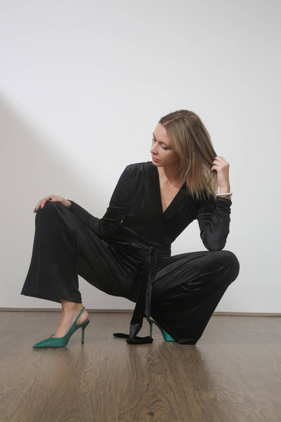 Serie of studio photos of young female model in elegant plush black jumpsuit - Photo, Image