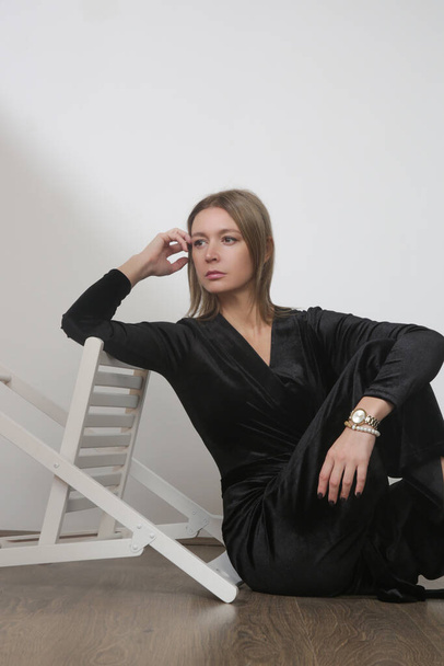 Serie of studio photos of young female model in elegant plush black jumpsuit - Foto, Imagen