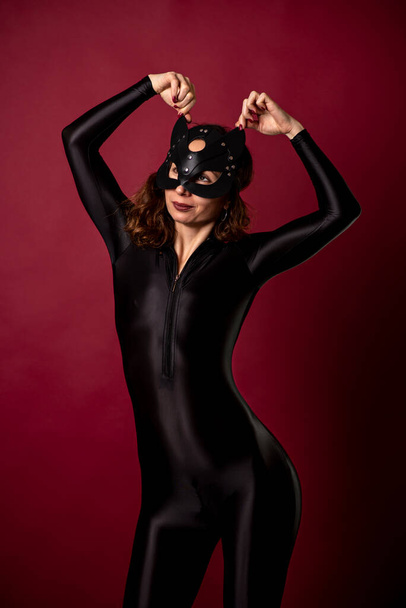 Sexy young woman with black bodysuit and cat mask. Adult role playing. - Photo, Image