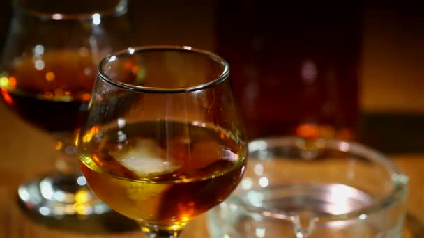 Hielo cae en un vaso con coñac, whisky de cerca
 - Metraje, vídeo