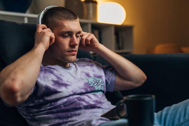 Closeup view of a Caucasian man putting on headphones - Foto, Imagem