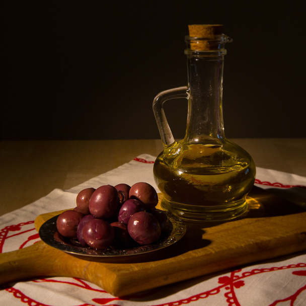 pot met olijfolie en sommige olijven - Foto, afbeelding