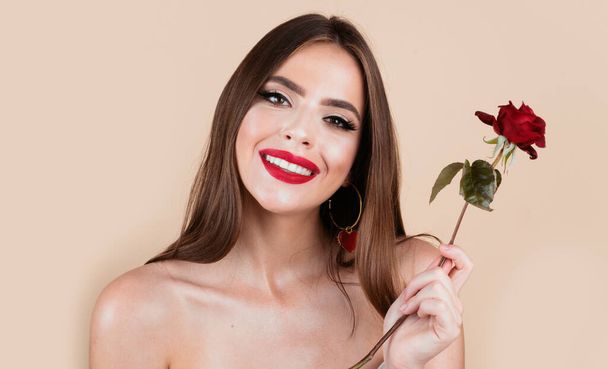 Beauty romantic smiling woman with red rose flowers. Beautiful luxury makeup. Valentines Day design. Portrait of fashion model girl on studio background. Beautiful fashion girl, headshot portrait - Фото, изображение