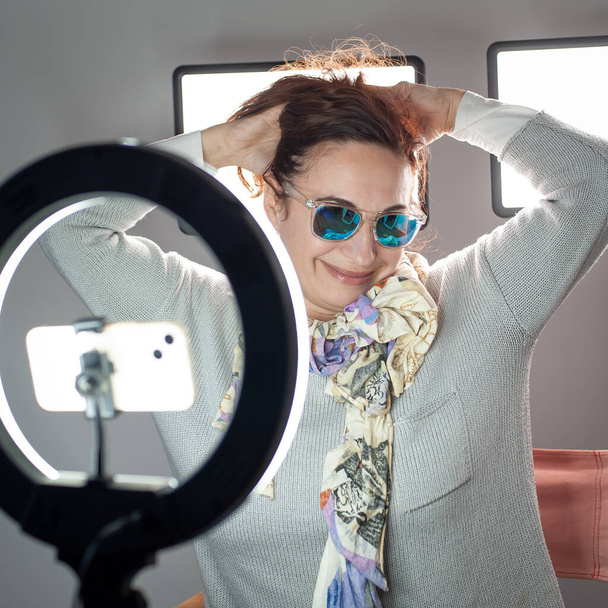 Portrait of stylish good-looking female blogger, lifestyle internet influencer. Smiling vlogger woman looking at mobile make video call, shooting vlog. - Valokuva, kuva