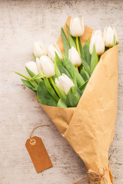 Букет белых тюльпанов на белом фоне, копировальное пространство. Пасха. Вид сверху - Фото, изображение
