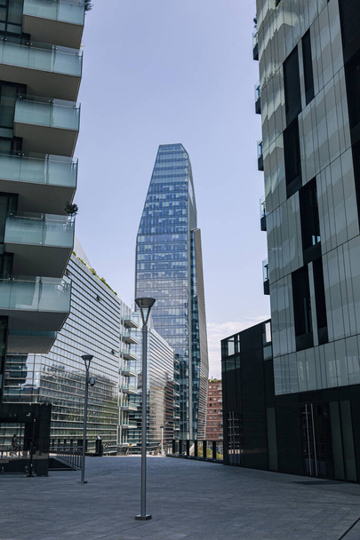 Над міським ландшафтом височить гладенький промисловий хмарочос, як міська вежа (Мілан, Італія). - Фото, зображення
