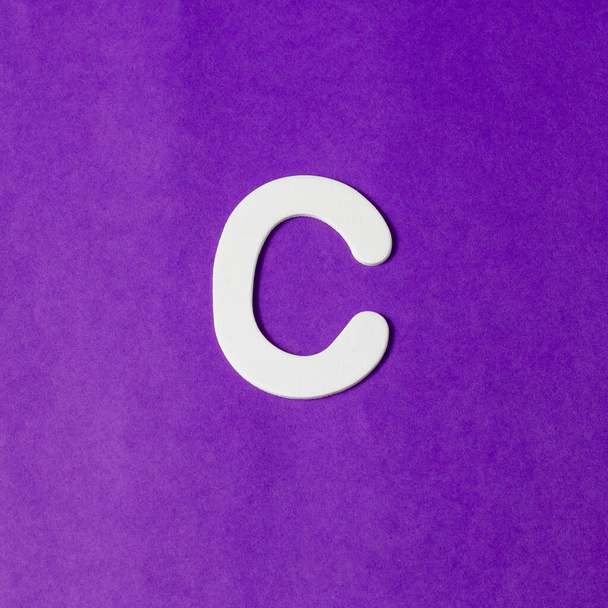 Letter C in wood texture - Purple background - Фото, изображение