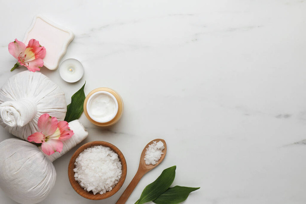 Flat lay composition with spa products and flowers on white marble table. Space for text - Foto, Imagen
