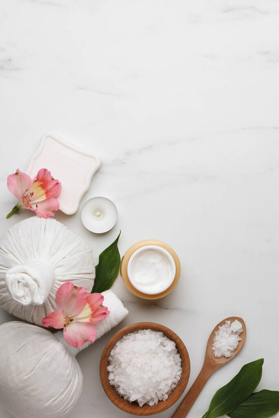 Flat lay composition with spa products and flowers on white marble table. Space for text - Photo, Image