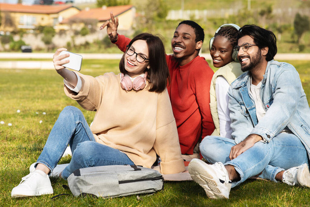 Щасливі тисячоліття різноманітні сучасні студенти дивляться на смартфон, телефонують, навчаються разом, роблять селфі в університетському містечку, на відкритому повітрі. Додаток для знань, освіти, блогу та способу життя
 - Фото, зображення