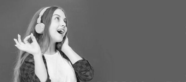 ok. happy teen girl in headphones. music lover. listen to music. wireless headset device accessory. Banner of schoolgirl student. School child pupil portrait with copy space - Foto, Bild