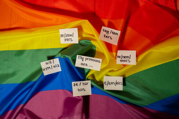 MIS PRONUNCIAS SON Neo pronombres concepto. Rainbow flag with paper notes text gender pronoms hie, e, ne, xe, ze, tey. Transgéneros no binarios de derechos humanos. El apoyo de la comunidad Lgbtq asume mi género - Foto, Imagen