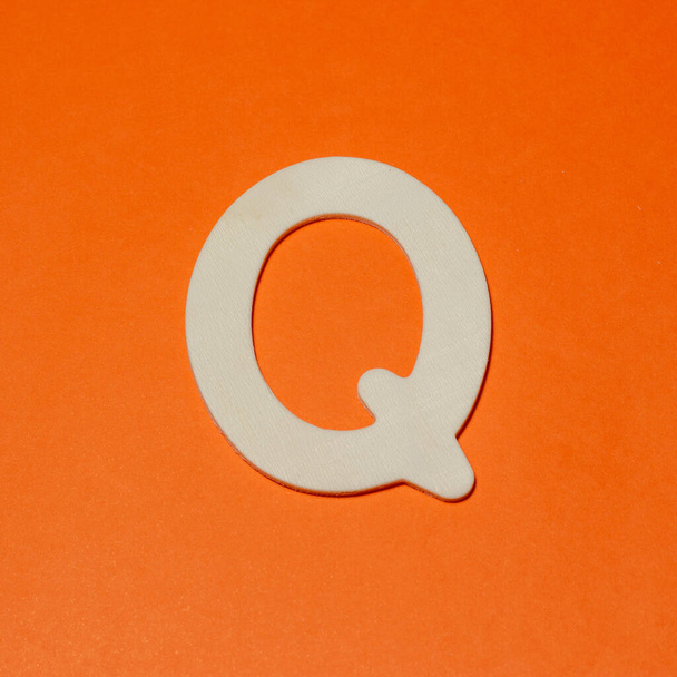 Uppercase letter Q - wood texture - Orange background - Foto, Imagen