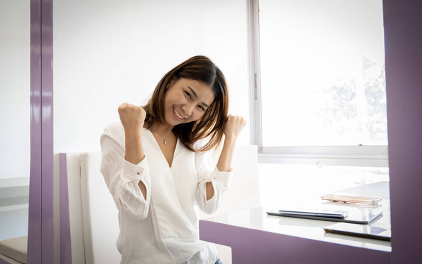 Красива азіатська бізнес-леді позує з радістю в її офісі
. - Фото, зображення