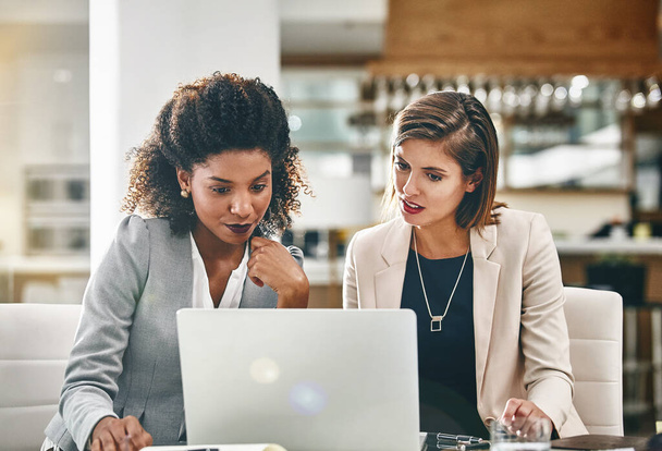 Het bereiken van de top komt niet zonder een goede strategie. twee zakenvrouwen werken samen op een laptop in een kantoor - Foto, afbeelding