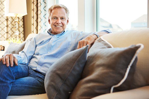 Enjoying a carefree and stress-free retirement. Portrait of a happy mature man relaxing on the sofa at home - Foto, Imagen
