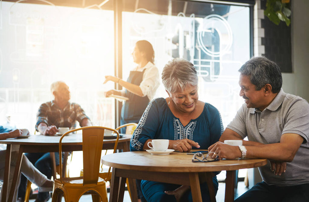 We feel more connected than ever before. a senior couple out on a date at a coffee shop - Photo, Image