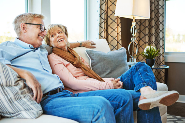 Жити щасливо після виходу на пенсію. зріла пара розслабляється разом на дивані вдома
 - Фото, зображення