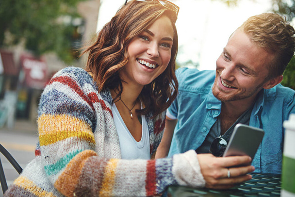 Aimer la vie en ville. un jeune couple heureux utilisant un smartphone ensemble tout en passant la journée au centre-ville - Photo, image