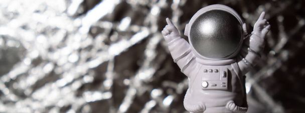 Gümüş arka plandaki plastik oyuncak figürlü astronot kopyalama uzayı. Dünya dışı seyahat kavramı, özel uzay adamı ticari uçuşları. Uzay görevleri ve Sürdürülebilirlik - Fotoğraf, Görsel