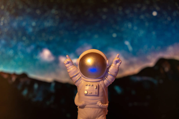Plastic toy astronaut on universe planets background Copy space. Concept of out of earth travel, private spaceman commercial flights. Space missions and Sustainability - Foto, Imagen