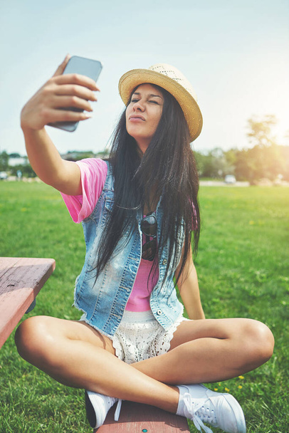 Si fa tutti i tipi di selfie. una giovane donna attraente che si fa dei selfie mentre trascorre una giornata nel parco - Foto, immagini