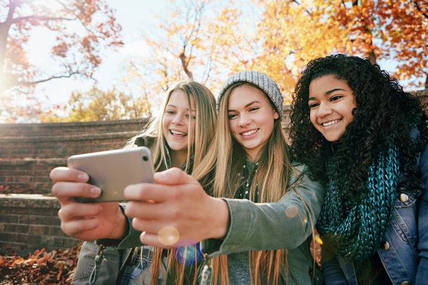 Maak jullie selfie gezichten klaar. een groep jonge vrienden poseren voor een selfie samen buiten - Foto, afbeelding