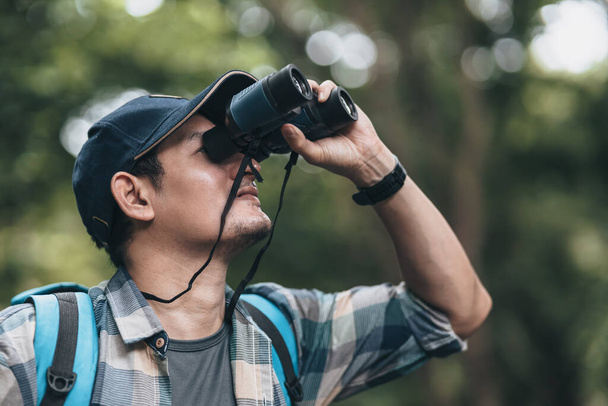 Hikers use binocular to see animals and view landscape  with backpacks in the forest. hiking and adventure concept. - Fotografie, Obrázek