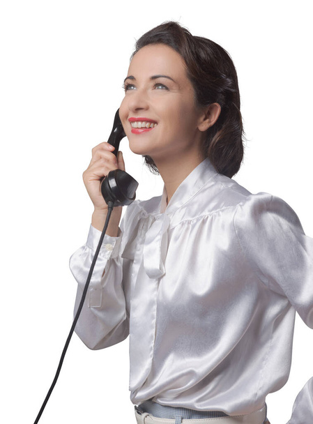 Attractive elegant vintage secretary having a phone call and smiling - Photo, image