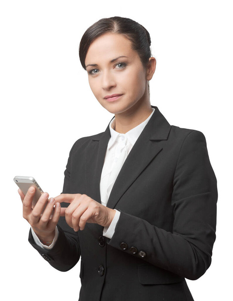 Smiling confident business woman using touch screen mobile phone. - Fotó, kép