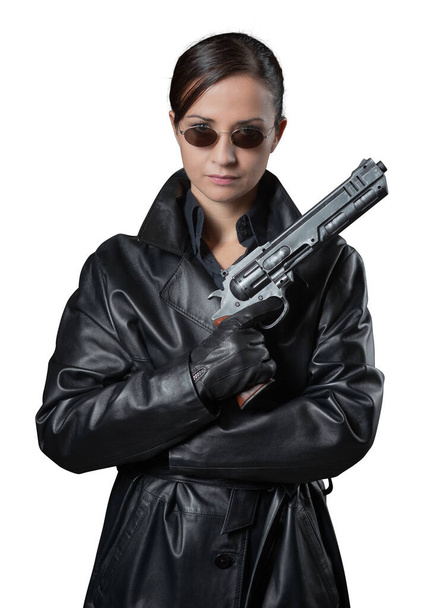 Attractive female agent in black leather coat and sunglasses holding a gun. - Fotoğraf, Görsel