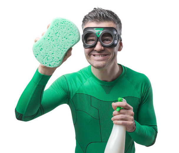 Smiling superhero cleaning with sponge and detergent. - Photo, image