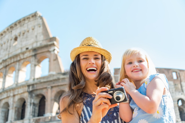 Happy mother and baby girl with photo camera near colosseum in r - Foto, imagen